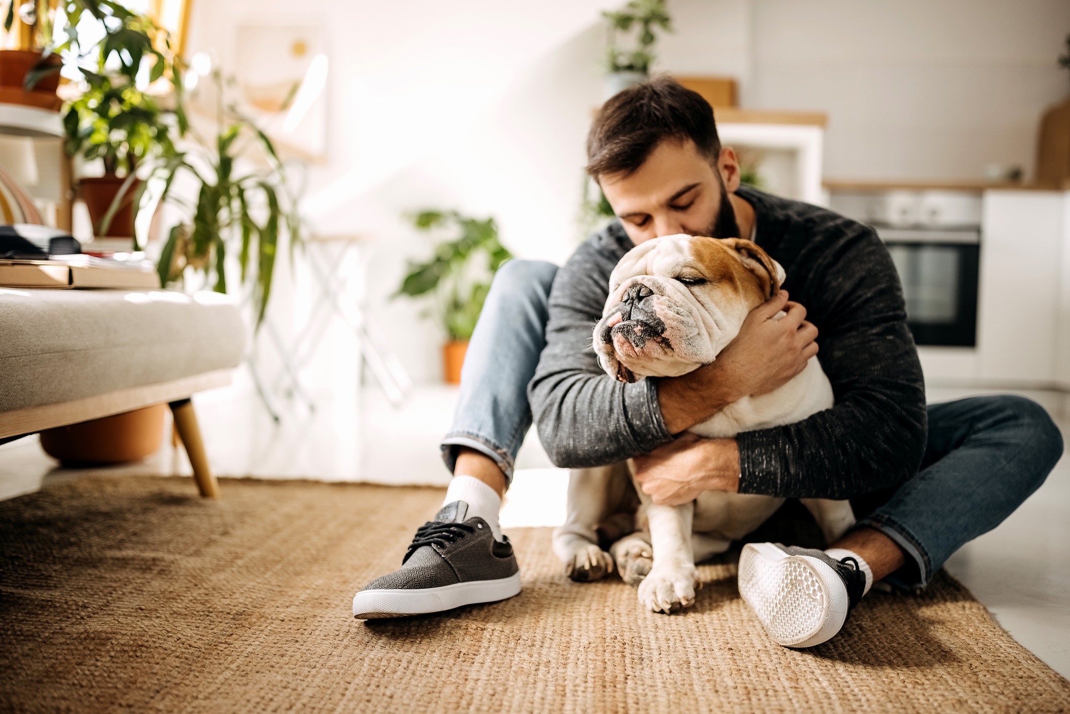 man hugging an english bulldog