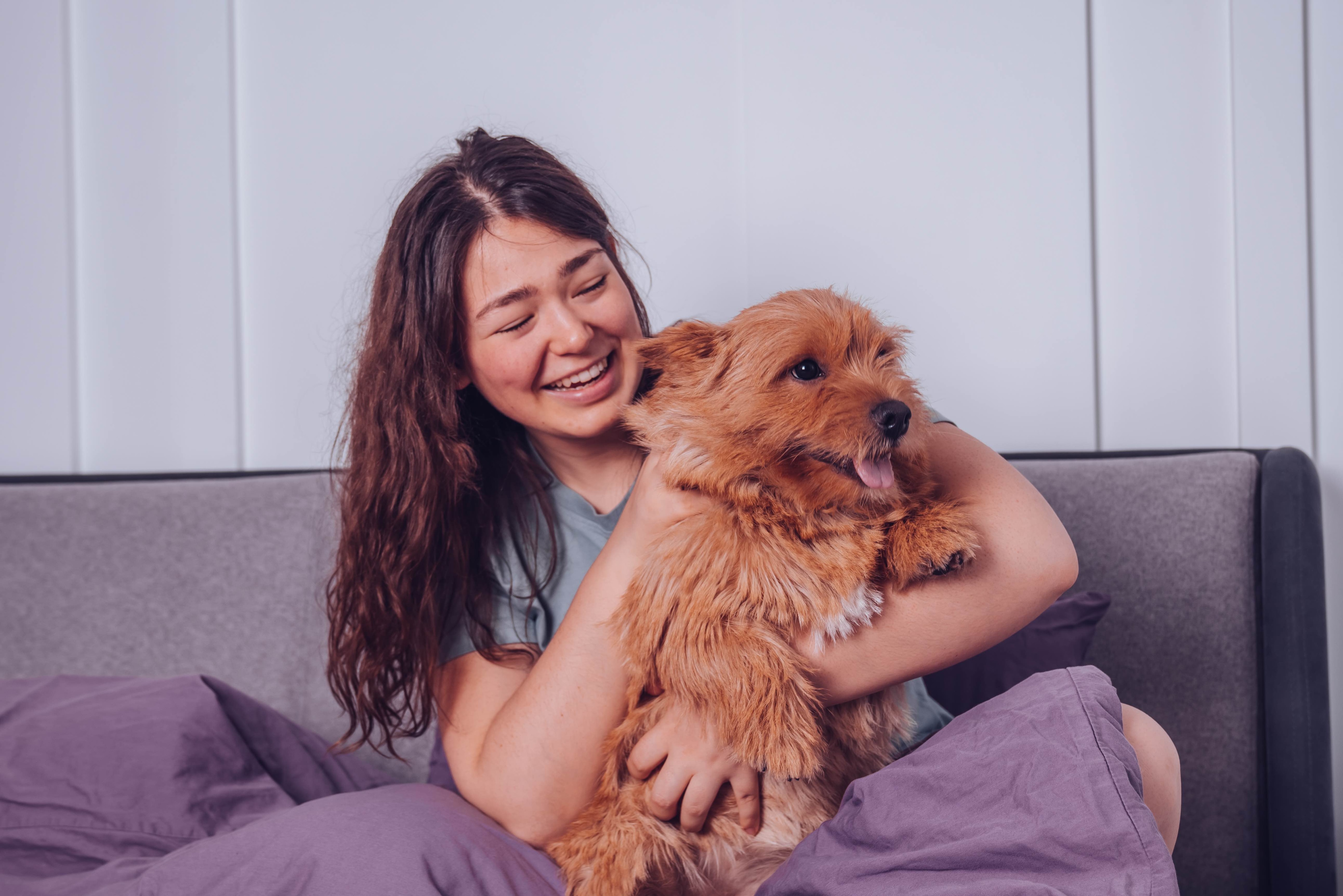 woman cradling a red norwich terrier