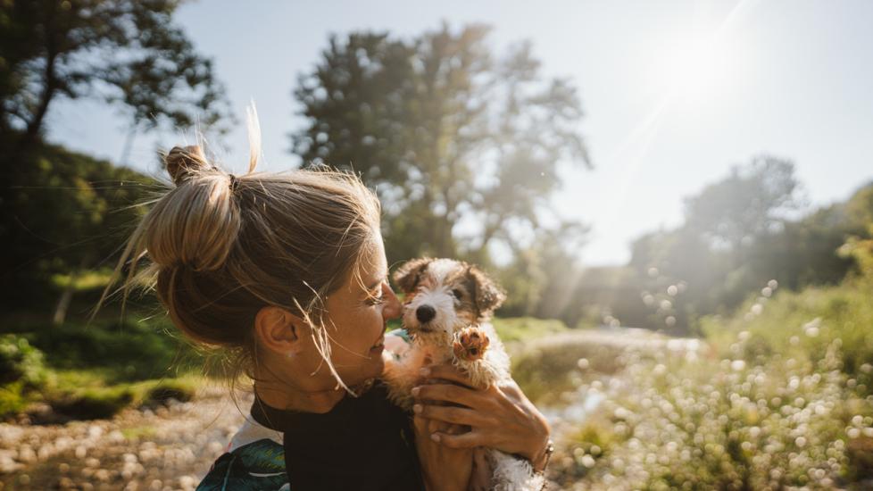 woman holding a puppy outside