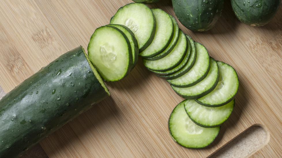 cucumber with cut slices on a cutting board