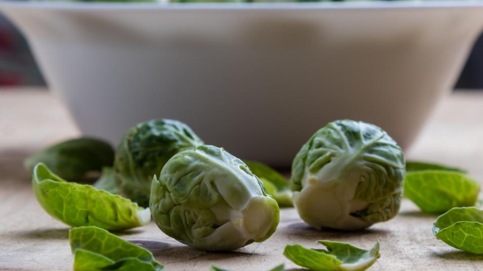 close-up of raw brussels sprouts in front of a white bowl