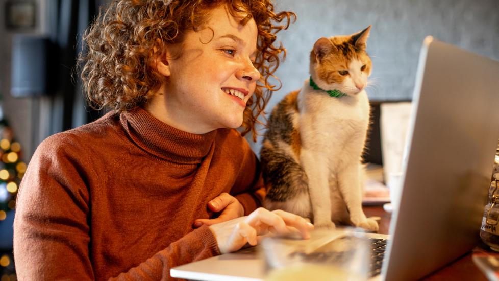 woman and cat looking at computer screen together
