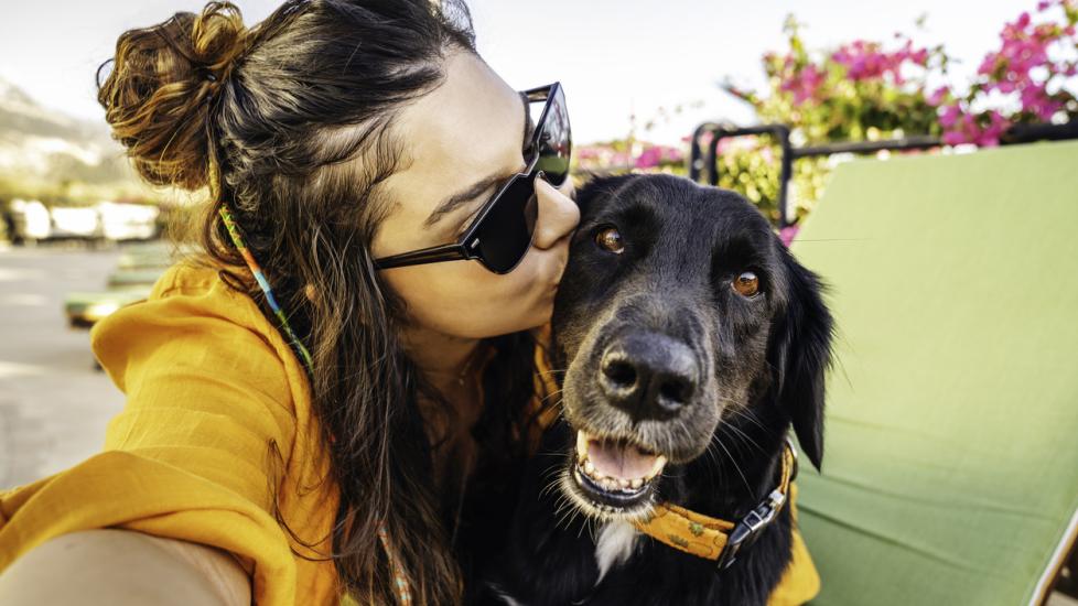 woman takes selfie of herself and black lab mix