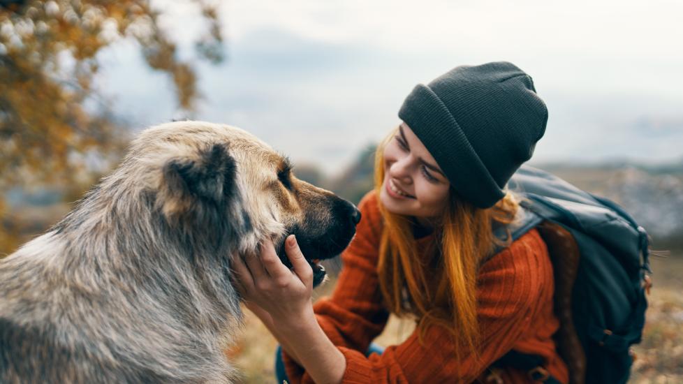 A woman smiles at her dog.