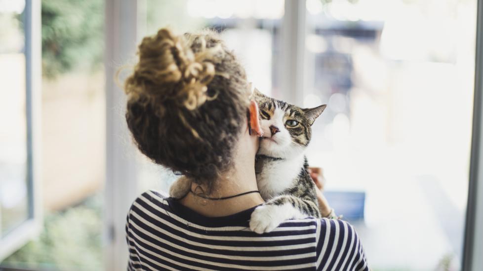 woman snuggling with cat