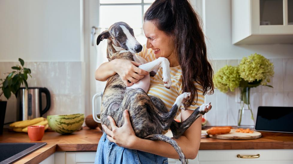 woman holding small dog and smiling